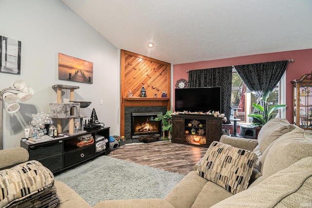 living room with wood-type flooring, a textured ceiling, and vaulted ceiling