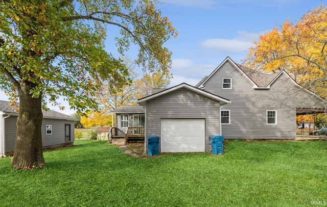 back of house featuring a garage and a lawn