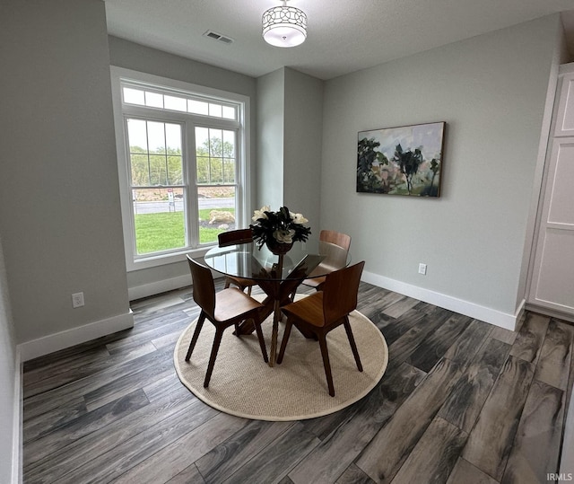 dining room featuring a textured ceiling and dark hardwood / wood-style flooring