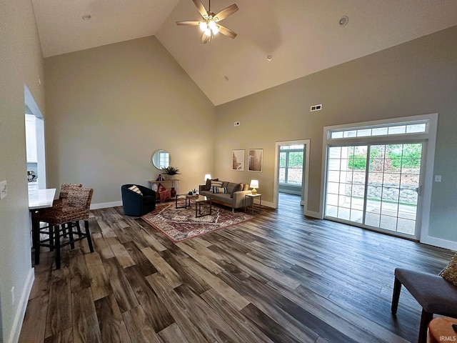 living room featuring dark hardwood / wood-style floors, high vaulted ceiling, and ceiling fan