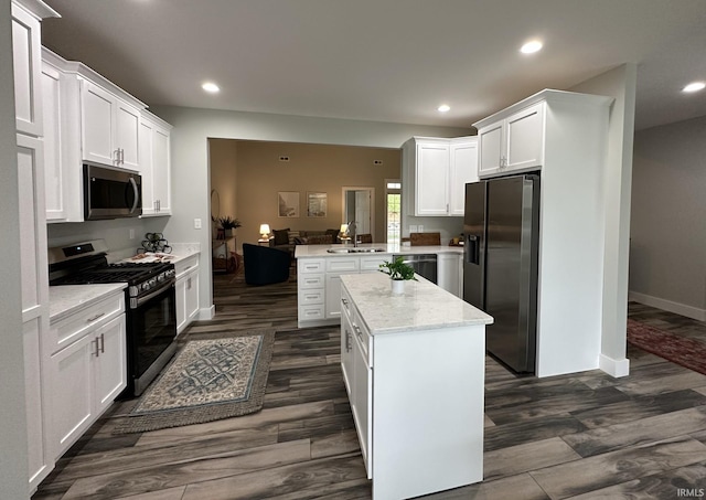 kitchen with appliances with stainless steel finishes, kitchen peninsula, dark hardwood / wood-style floors, and white cabinets