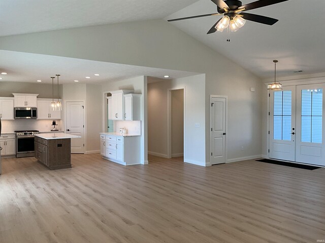 kitchen with stainless steel appliances, white cabinetry, pendant lighting, and a center island