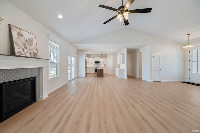 4848 Abbeyville Dr, Lafayette, IN 47909 - unfurnished living room featuring lofted ceiling, light wood-style floors, a tiled fireplace, a ceiling fan, and baseboards