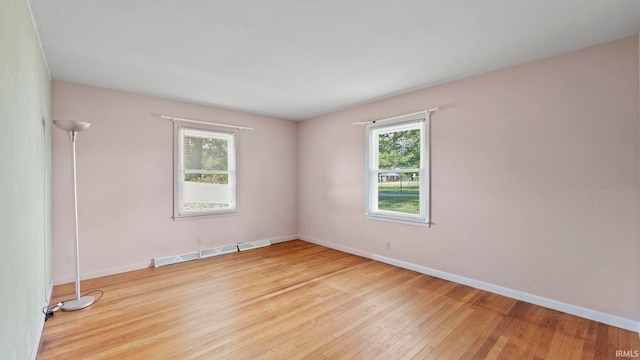 spare room with light hardwood / wood-style flooring and plenty of natural light