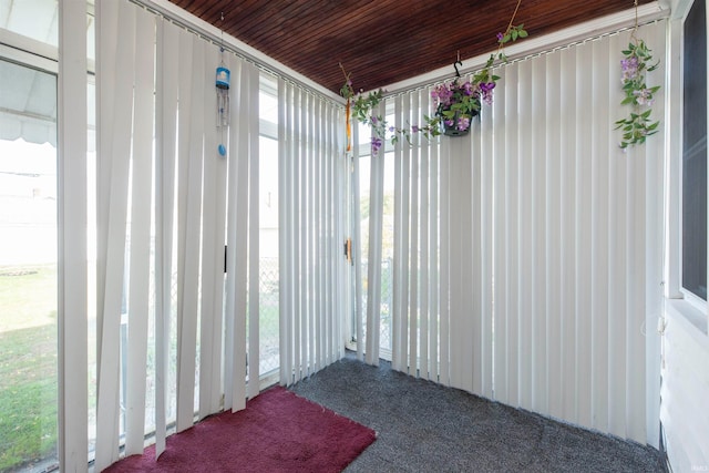 unfurnished sunroom with a healthy amount of sunlight and wooden ceiling