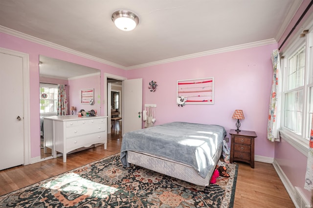 bedroom featuring crown molding and light hardwood / wood-style floors