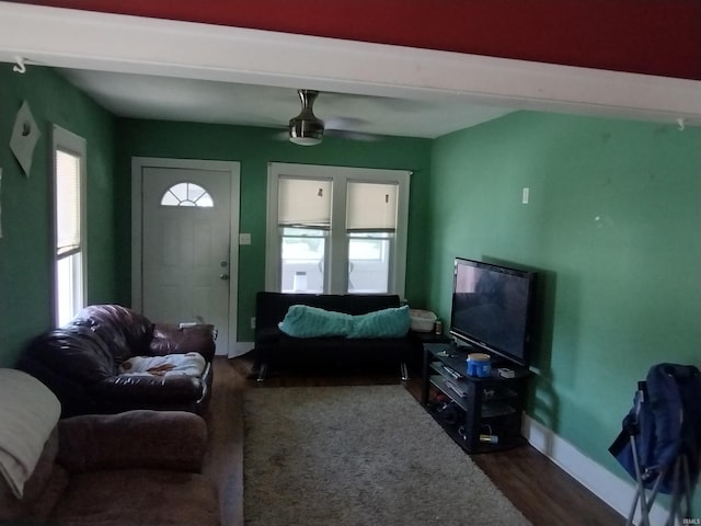 living room featuring dark wood-type flooring and ceiling fan