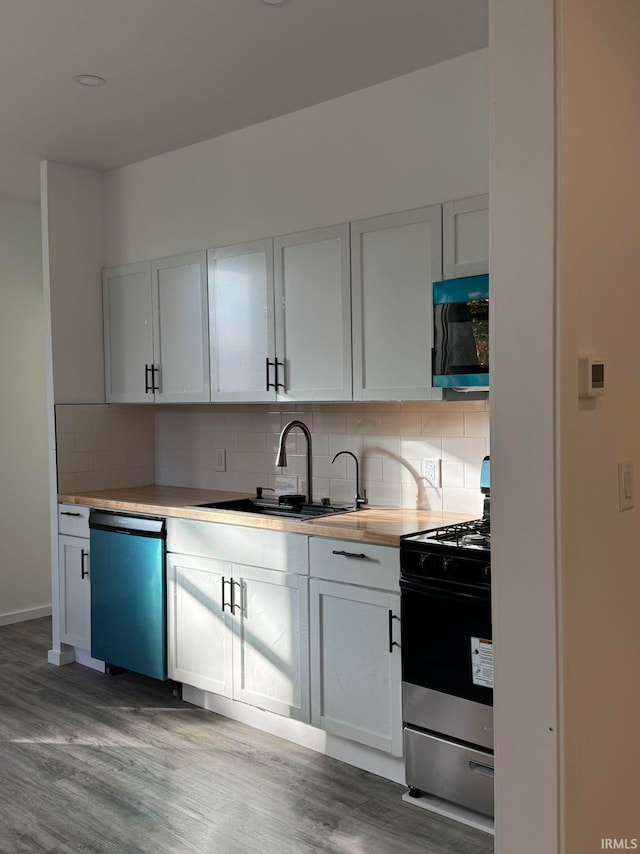 kitchen featuring dark hardwood / wood-style floors, sink, white cabinetry, appliances with stainless steel finishes, and tasteful backsplash