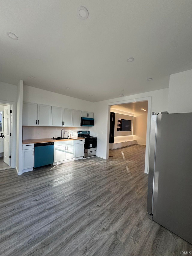 kitchen featuring white cabinetry, hardwood / wood-style flooring, appliances with stainless steel finishes, and sink