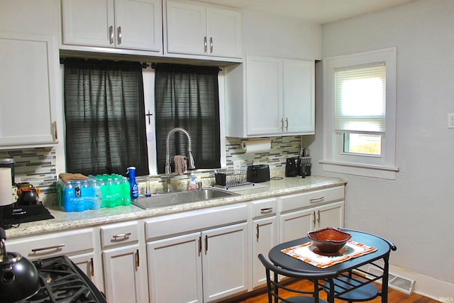 kitchen featuring white cabinetry, tasteful backsplash, and sink