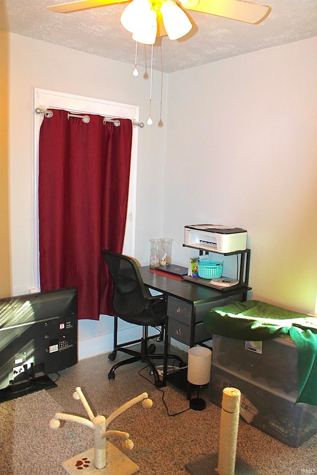 carpeted home office with a textured ceiling and ceiling fan