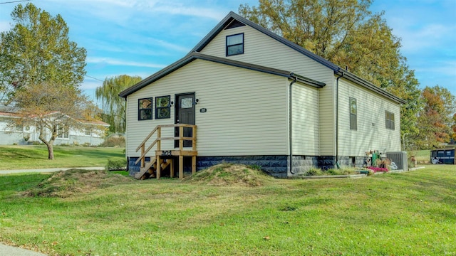 back of property featuring a yard and central AC unit