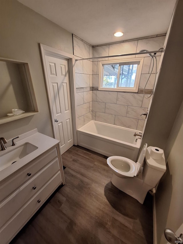 full bathroom featuring vanity, toilet, tiled shower / bath combo, and wood-type flooring