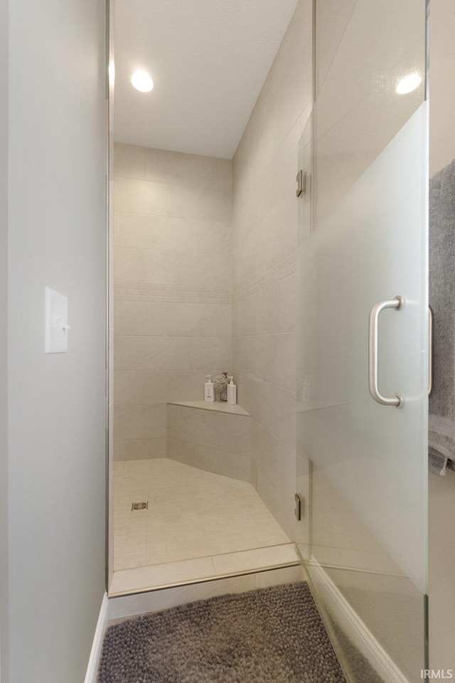 bathroom featuring a shower with door and tile patterned flooring