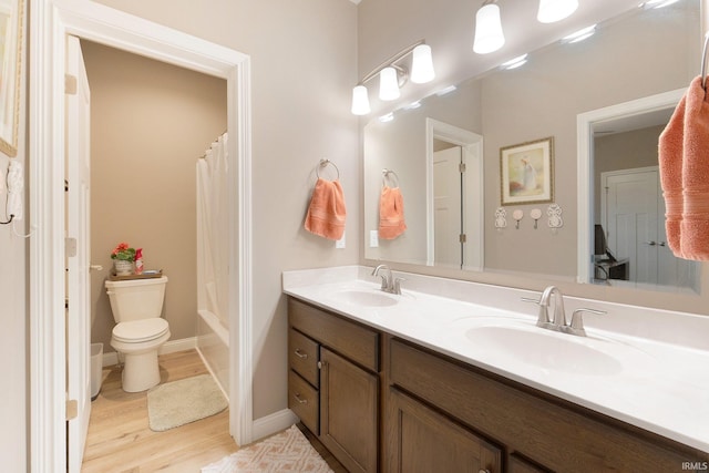 bathroom with toilet, hardwood / wood-style floors, and vanity