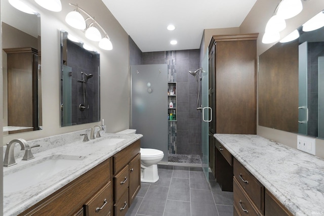 bathroom with vanity, a shower with shower door, toilet, and tile patterned floors