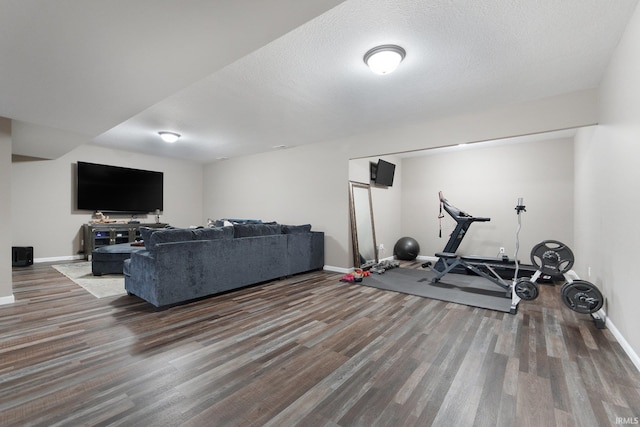 workout area featuring a textured ceiling and dark wood-type flooring