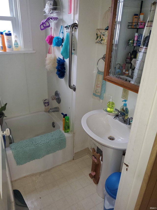 bathroom with shower / bathtub combination with curtain and sink