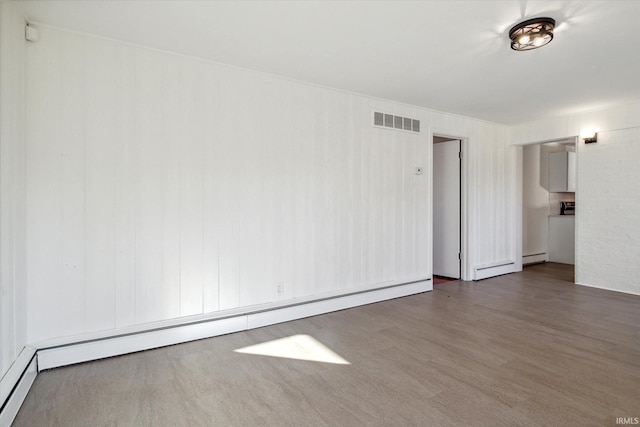 unfurnished room featuring dark wood-type flooring and a baseboard radiator