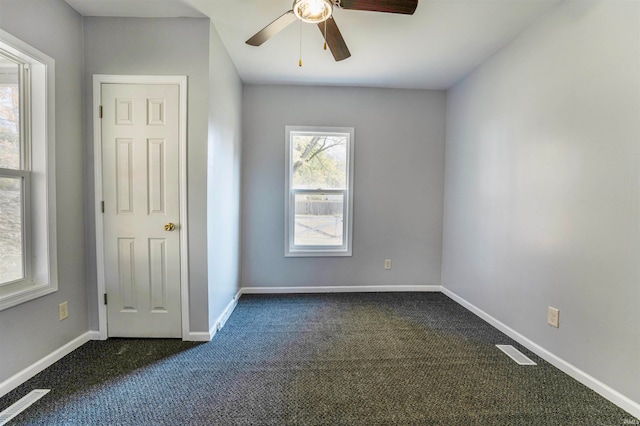 unfurnished bedroom featuring ceiling fan and dark carpet