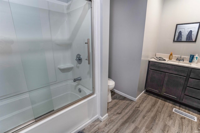 full bathroom featuring toilet, enclosed tub / shower combo, vanity, and wood-type flooring