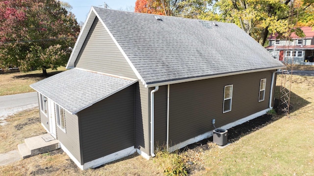 view of property exterior featuring central air condition unit and a lawn