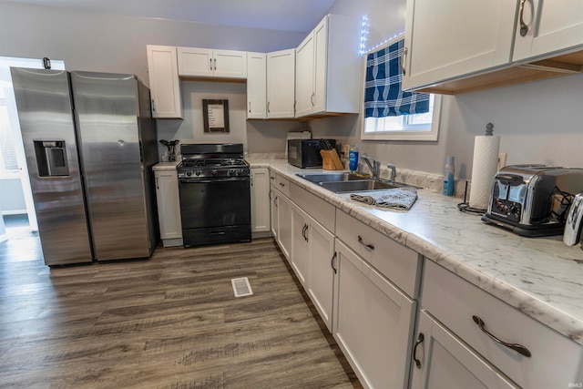 kitchen with sink, dark wood-type flooring, stainless steel fridge with ice dispenser, and black gas stove