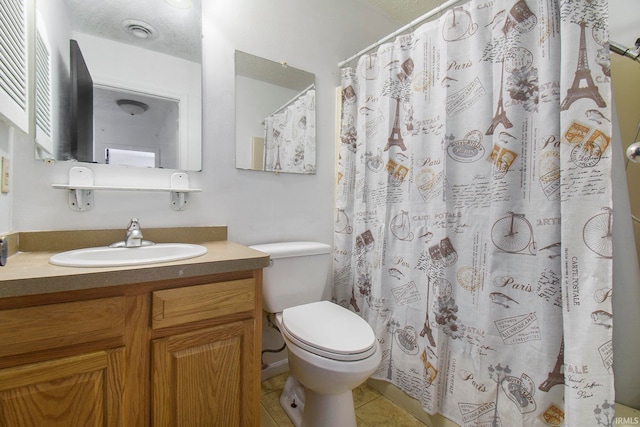 bathroom with a textured ceiling, toilet, vanity, curtained shower, and tile patterned floors