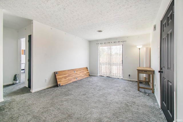 interior space featuring carpet flooring and a textured ceiling