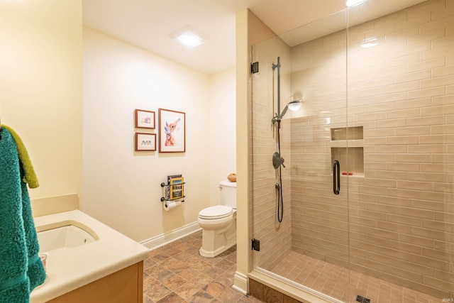 bathroom with vanity, a shower with shower door, and toilet