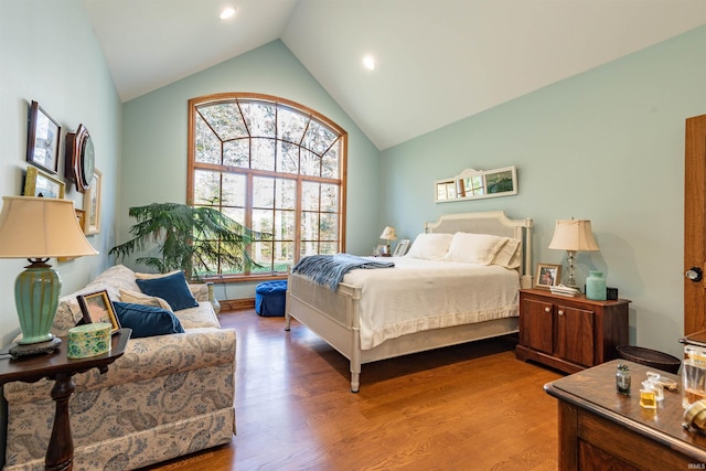 bedroom with high vaulted ceiling and wood-type flooring