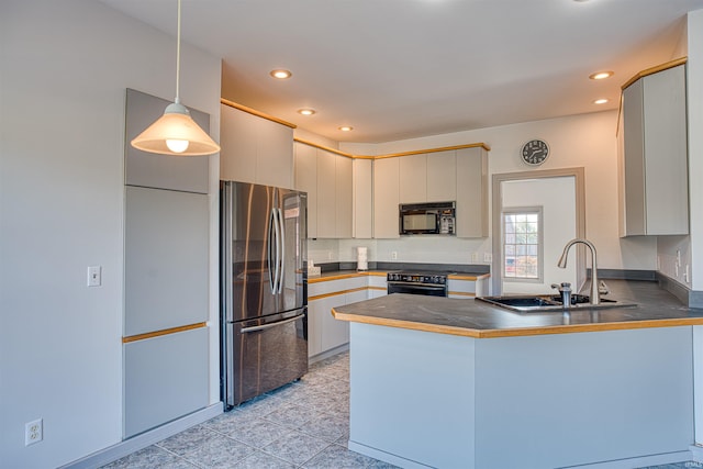 kitchen featuring pendant lighting, black appliances, sink, and kitchen peninsula