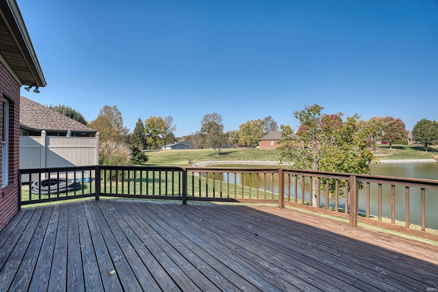 wooden terrace featuring a water view and a yard