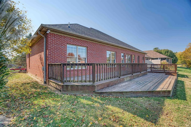 rear view of property with a deck and a lawn