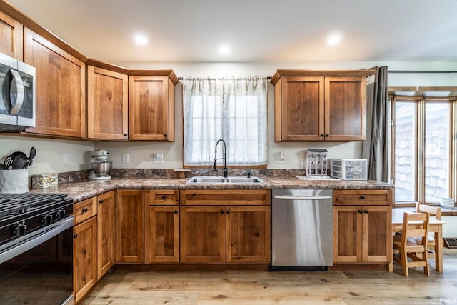 kitchen featuring stainless steel appliances, sink, and light wood-type flooring