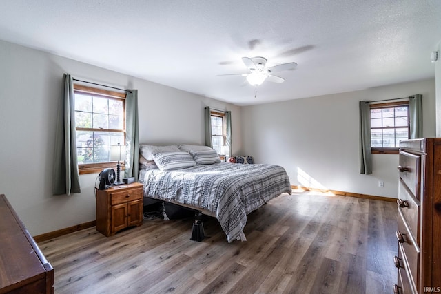 bedroom featuring a textured ceiling, light hardwood / wood-style floors, and ceiling fan