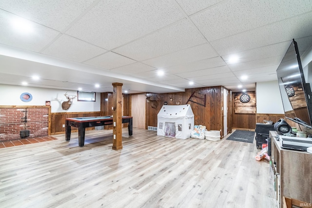 playroom with light hardwood / wood-style floors, wood walls, a drop ceiling, and pool table