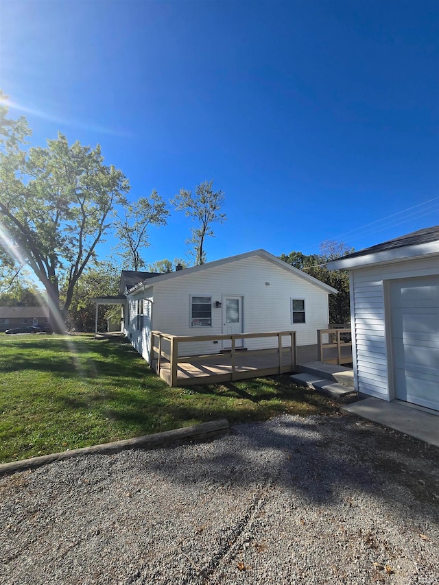 view of property exterior with a deck, a lawn, and a garage