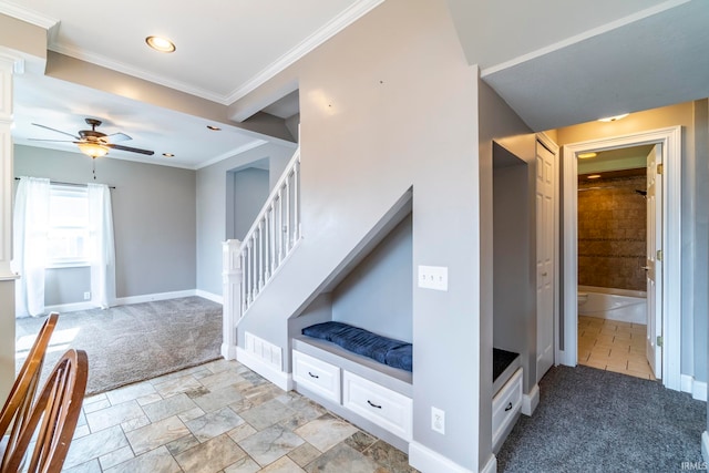 stairway with ornamental molding, carpet floors, and ceiling fan