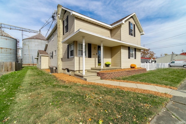 view of front of house featuring a front yard, central AC unit, and a porch