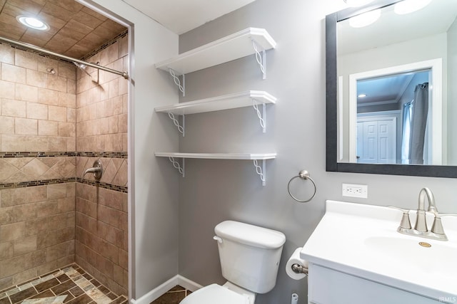 bathroom with toilet, vanity, tile patterned floors, and tiled shower