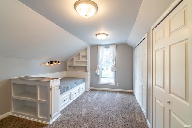 unfurnished bedroom featuring vaulted ceiling and dark carpet