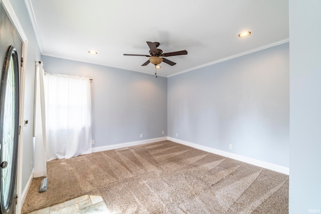 carpeted spare room featuring crown molding and ceiling fan