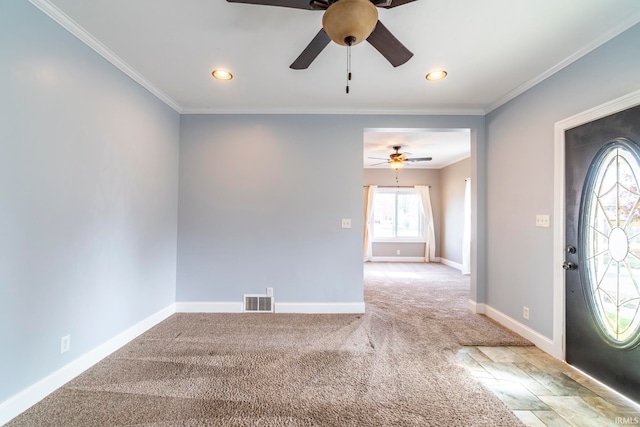 carpeted foyer featuring ornamental molding and ceiling fan