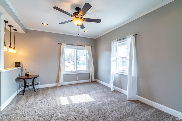 carpeted spare room featuring ornamental molding and ceiling fan