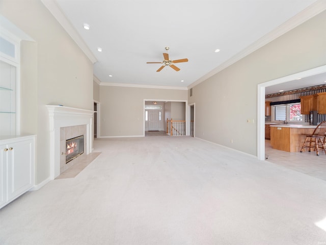 carpeted living room with crown molding, a fireplace, and ceiling fan