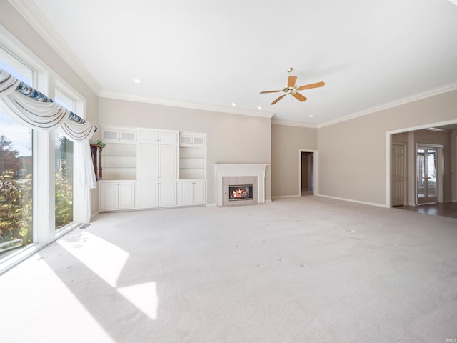 unfurnished living room with crown molding, light colored carpet, and ceiling fan