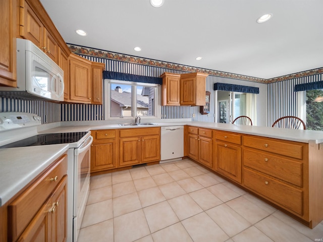 kitchen with white appliances, light tile patterned flooring, kitchen peninsula, and sink