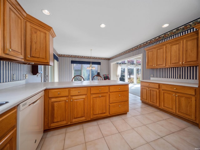 kitchen with white dishwasher, kitchen peninsula, pendant lighting, and a wealth of natural light