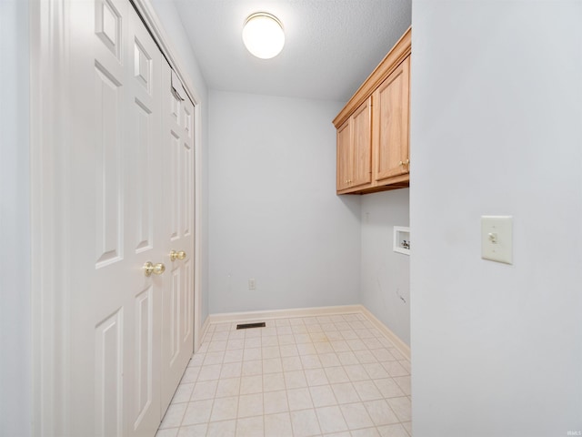 washroom featuring cabinets, hookup for a washing machine, a textured ceiling, and light tile patterned flooring